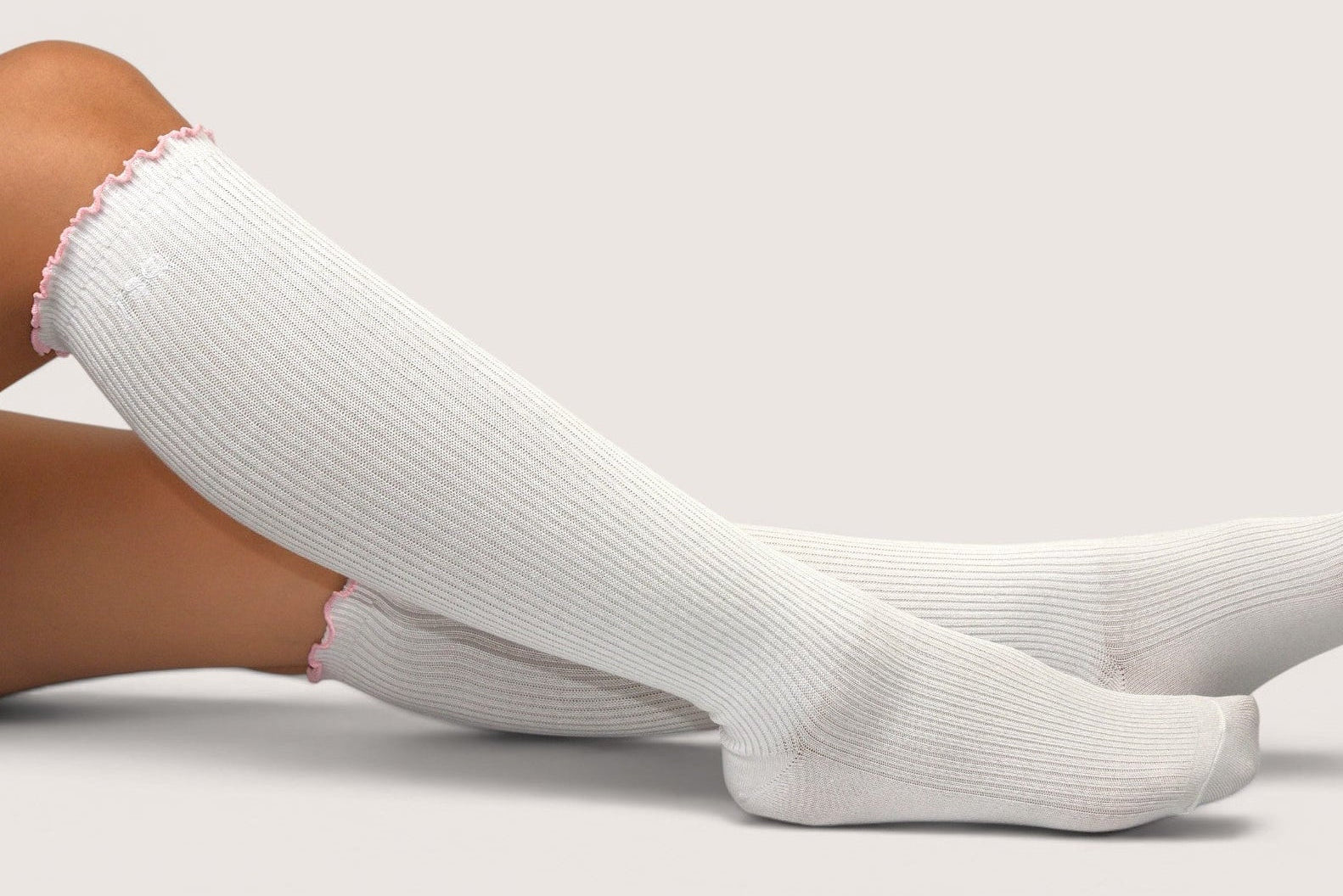 White socks worn by a person on a light gray background